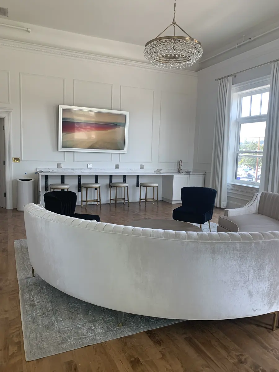The finished lounge: velvet sectional and chairs under the chandelier.