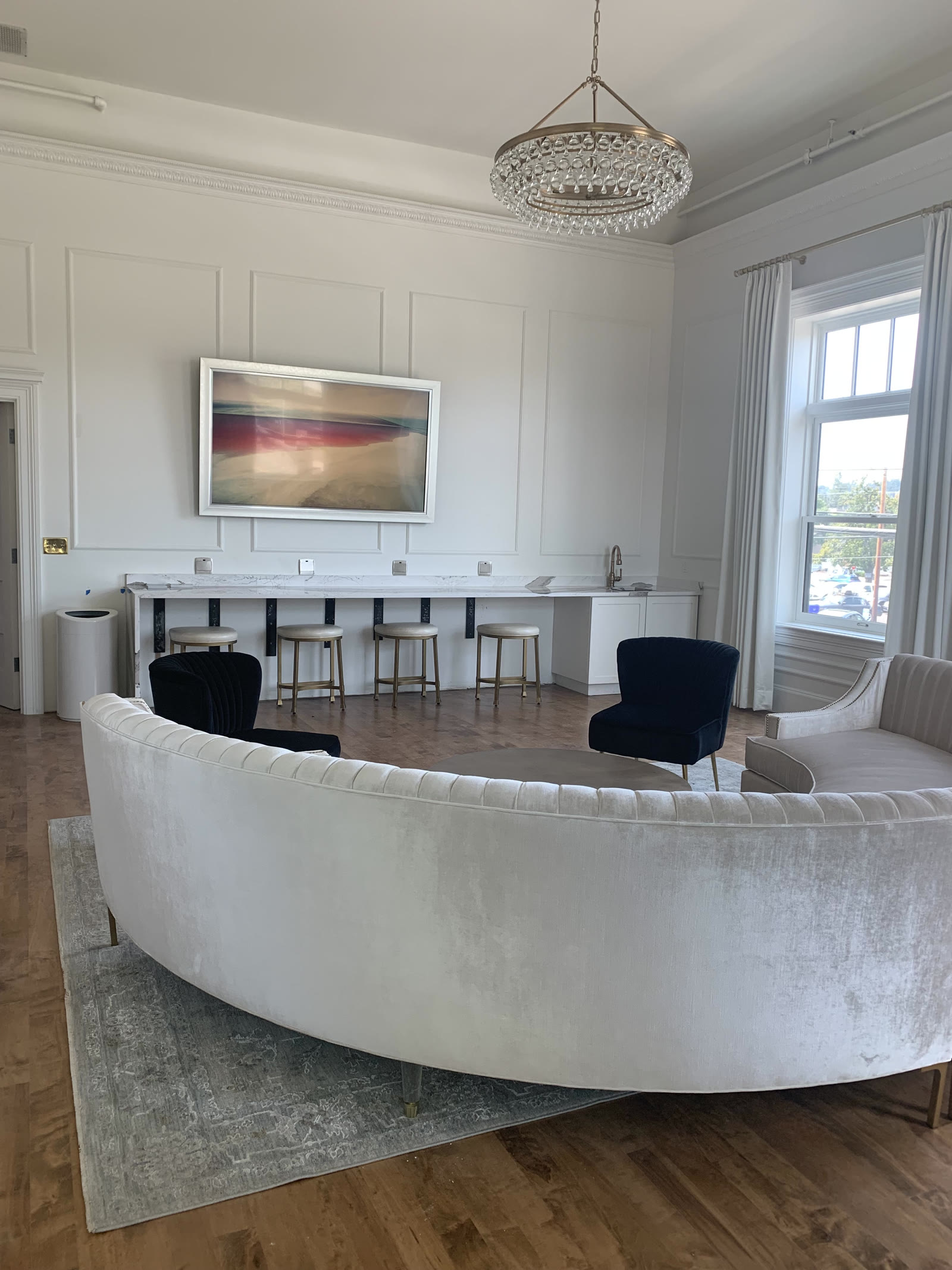 Finished lounge space: velvet seating and a chandelier, ready for the A/V behind the walls to do its job.