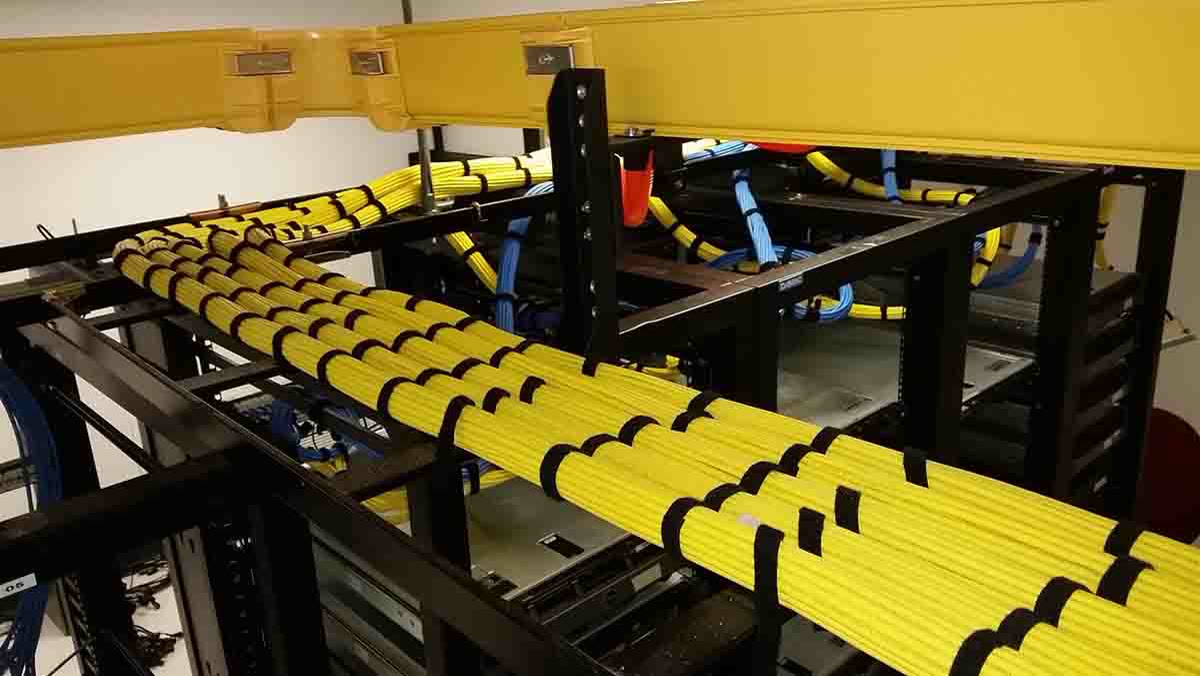 Combed and Velcro'd fiber bundles on an overhead cable tray in a server room